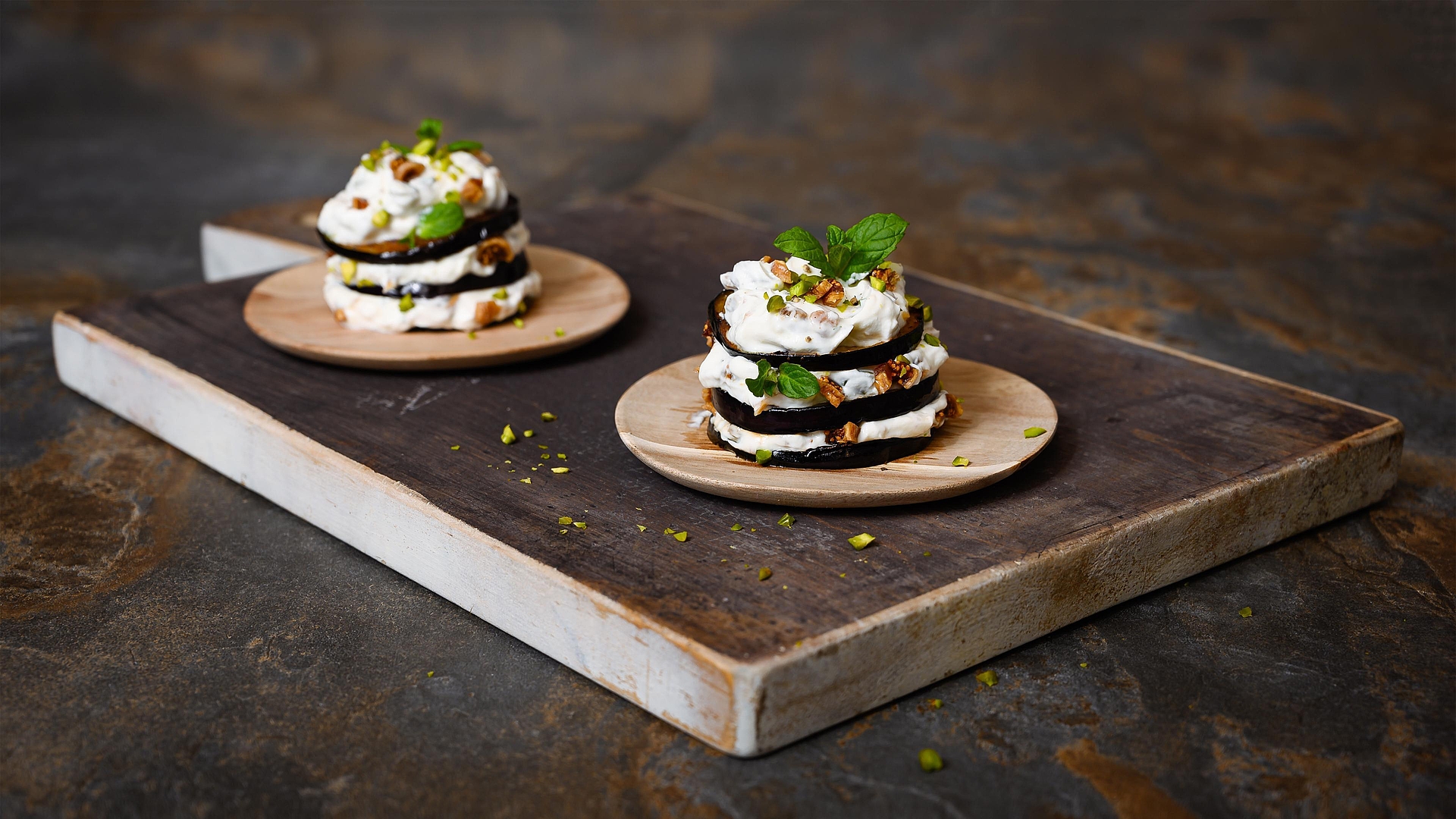 Aubergine towers with goat's cheese, pistachios, mint and dried figs