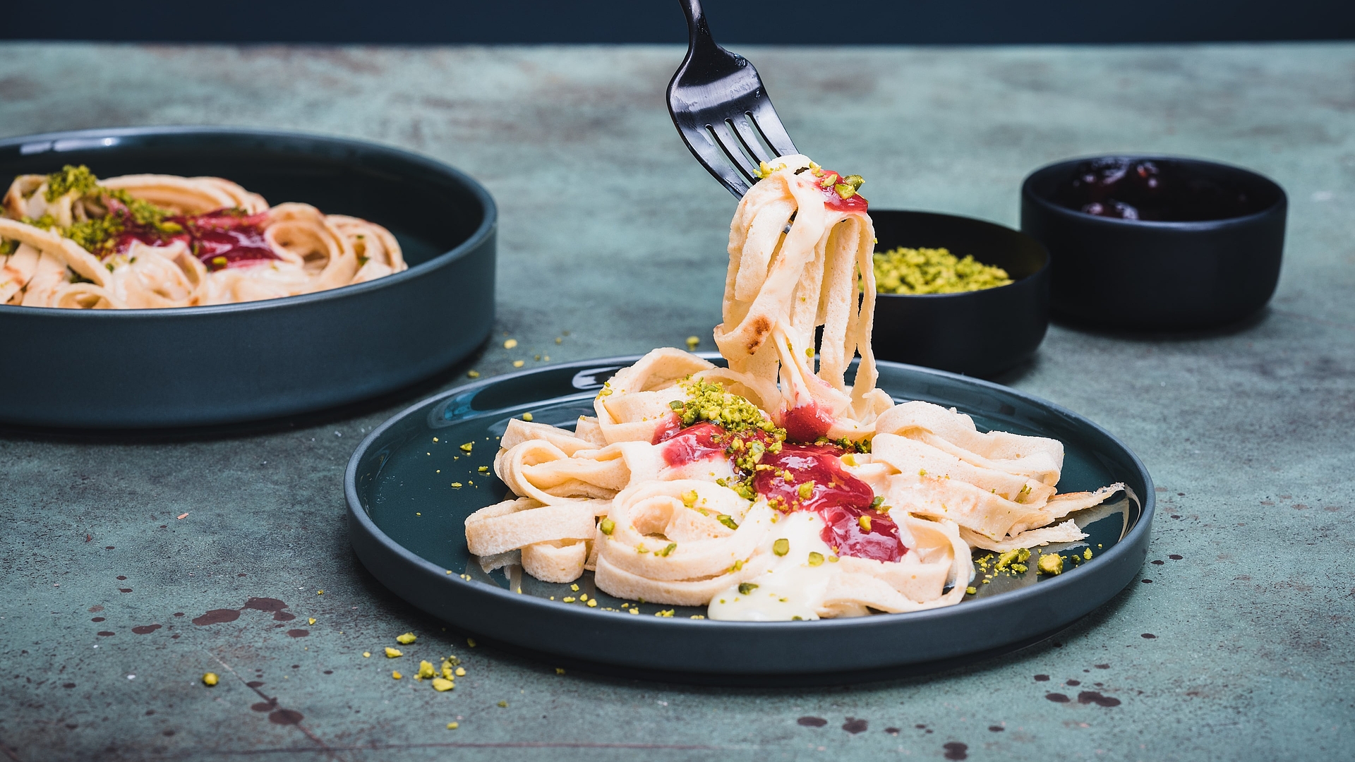 Sweet tagliatelle with raspberry sauce, white chocolate and pistachios