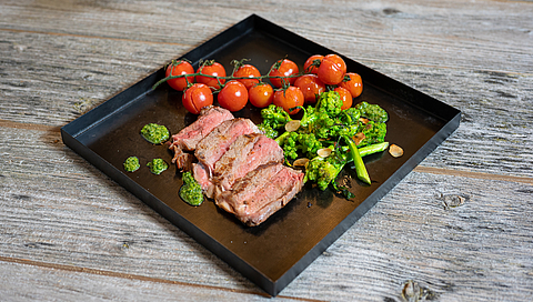 Entrecôte steak with broccolini, almonds, grilled cherry tomatoes and herbal salsa