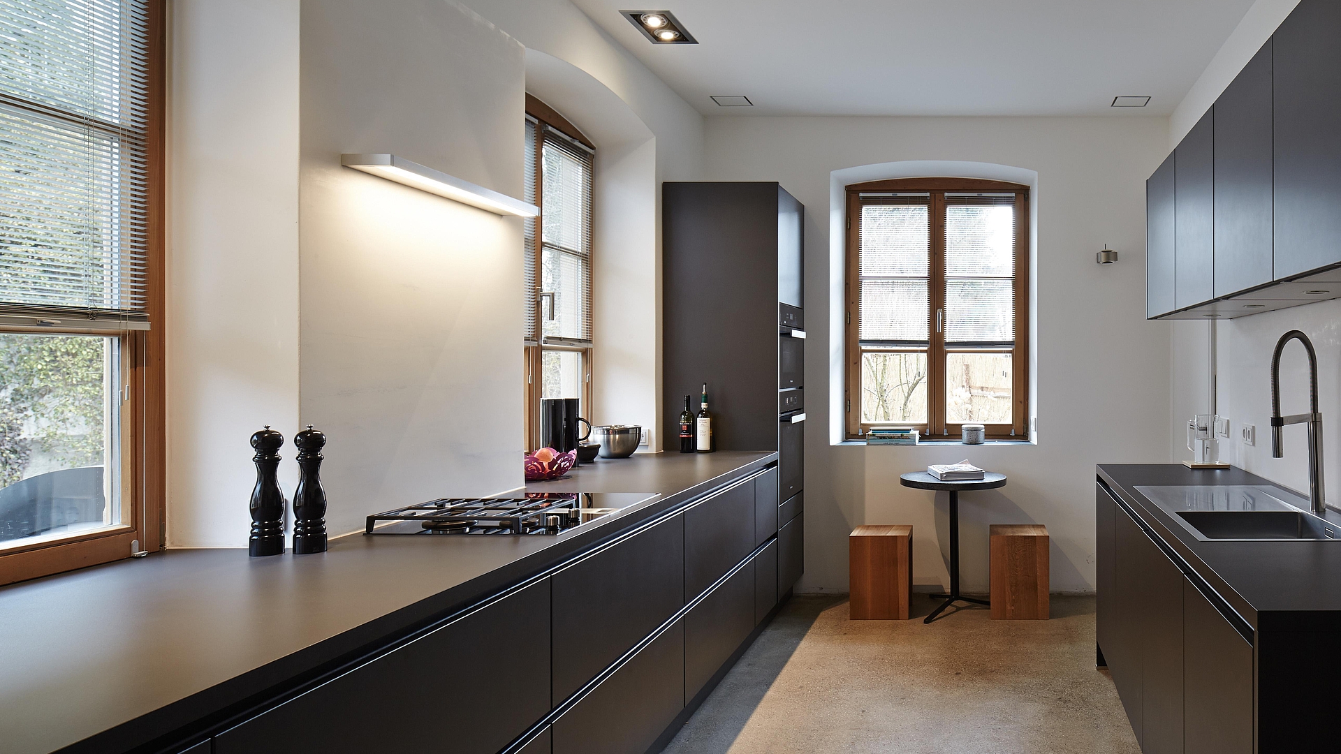 Geradlinigkeit in der Küche: Schwarzer Satinlack, Edelstahl und Glas